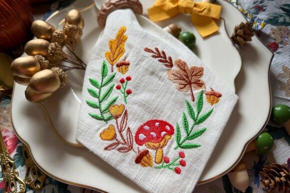 Fall embroidery designs featuring leaves, acorns, berries, and a red mushroom on white fabric