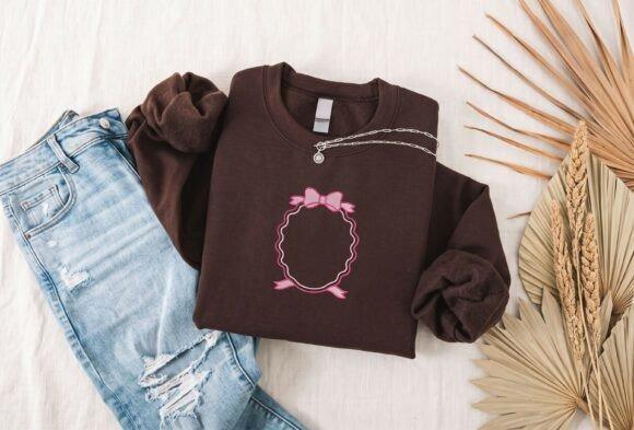Brown sweatshirt with pink scalloped oval bow monogram frame embroidery laid next to ripped — embroidery sweatshirt ideas