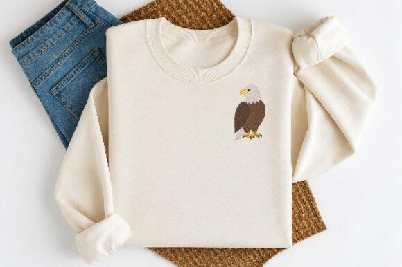 Beige sweatshirt with a bird embroidery design of a bald eagle on the chest — bird embroidery designs