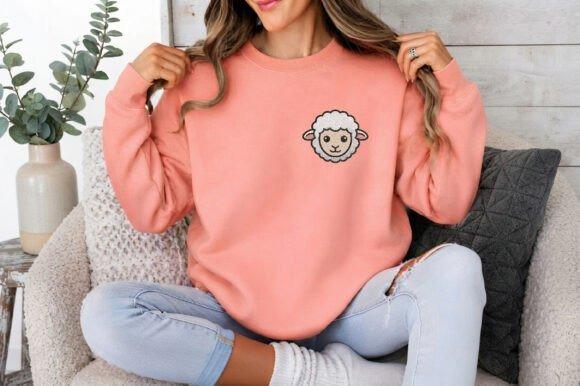 Woman wearing a peach sweatshirt with a small embroidered sheep face design on the chest, sitting on a — animal embroidery