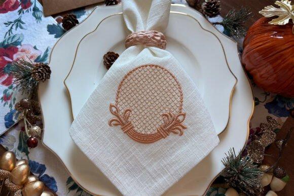 Decorative Frame monogram embroidery on white napkin with gold-rimmed plates and festive table decor
