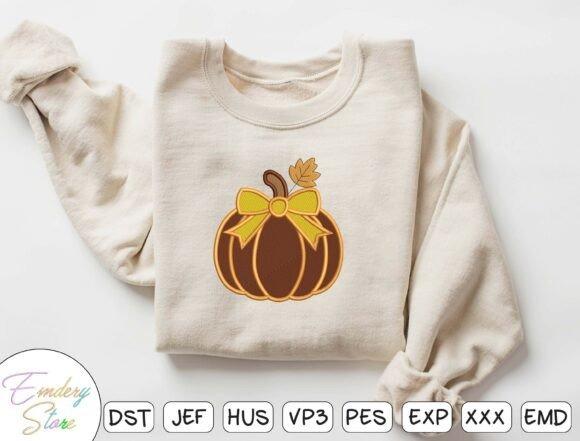 fall embroidery designs featuring a plump pumpkin with a yellow bow and autumn leaf on a beige sweatshirt