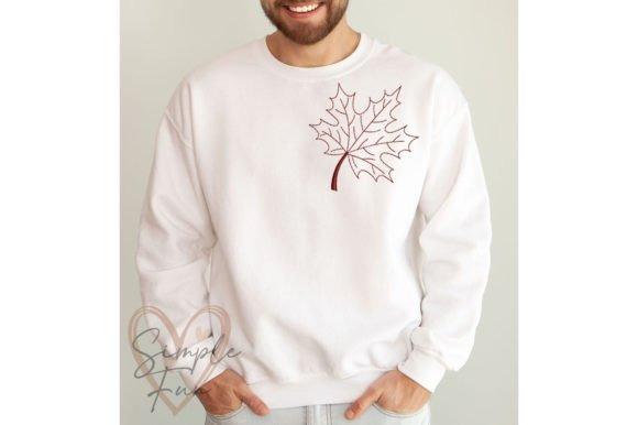 White sweatshirt with a single detailed fall leaf embroidery on the upper chest