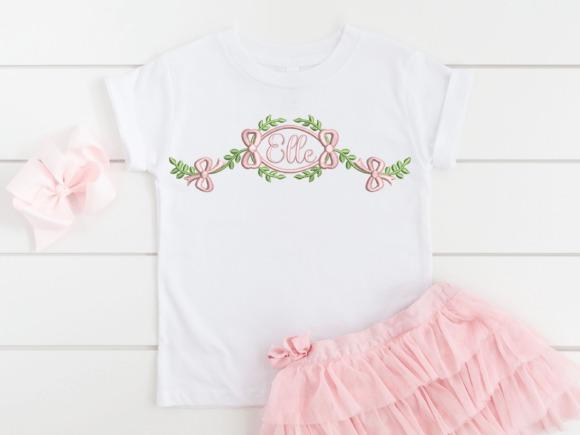 White t-shirt with a pink and green foliage bow monogram embroidery design reading 'Elle'