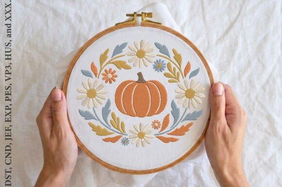 Pumpkin embroidery designs featuring a pumpkin surrounded by embroidered flowers in a wooden hoop