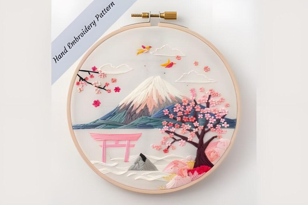 Hand embroidery patterns featuring Japanese landscape with Mount Fuji, cherry blossoms, torii gate, and birds in a round hoop