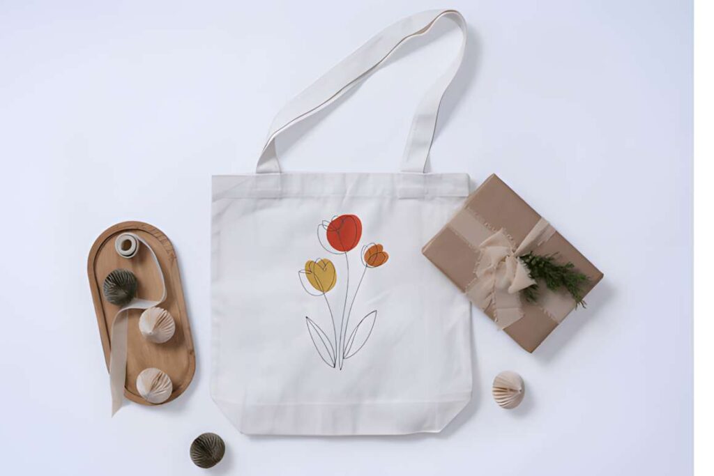 Machine embroidery designs for various styles on a white tote bag with minimalist floral embroidery