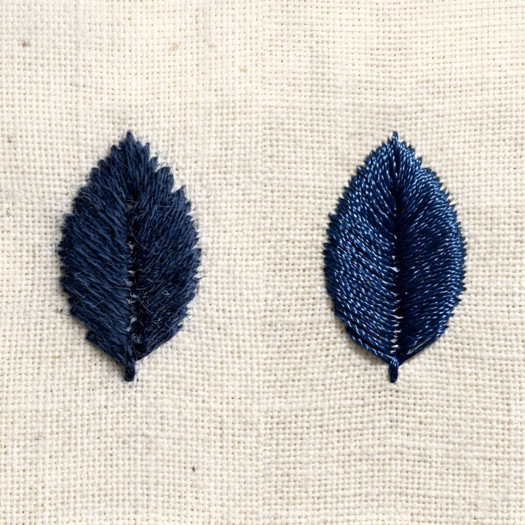 Close-up of two blue embroidered leaves showing difference in thread texture on fabric for embroidery machine