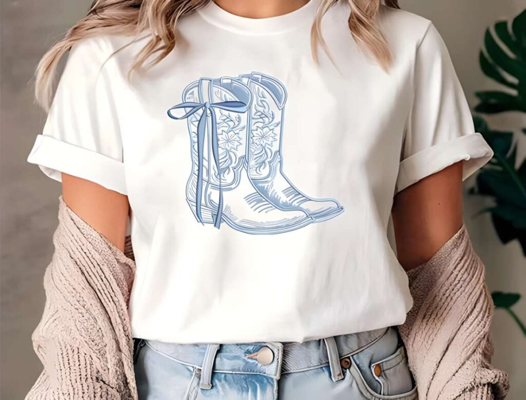 White t-shirt with machine embroidery designs for various styles featuring cowboy boots with floral detailing